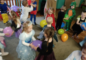 Dzieci stoją w parach, pomiędzy sobą trzymają balona.