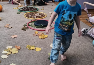 Chłopiec masyje stopę na kolbie kukurydzy.