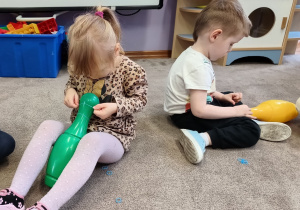 Dzieci zakładają gumki na kręgle.