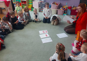 Dzieci siedzą na dywanie i biorą udział w quizie wiedzy o Polsce.
