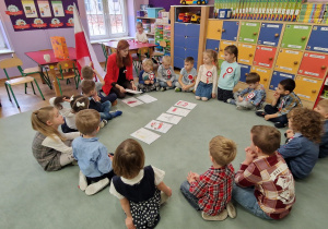 Dzieci siedzą w kole i biorą udział w quizie wiedzy o Polsce.