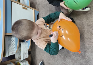 Chłopiec rysyje flamastrem na balonie nos.
