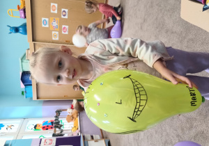 Dziewczynka prezentuje swój ozdobiony balon.