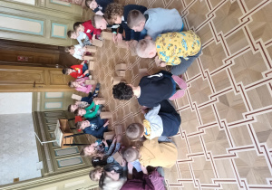 Dzieci na podłodze szukają ukrytych liter
