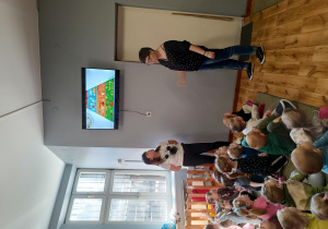 Prowadząca zabawy prezentuje na ekranie i omawia piramidę żywienia.