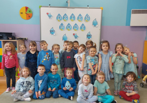 Dzieci ubrane na niebiesko pozują do zdjęcia w tle jest napis Dzień Wody.