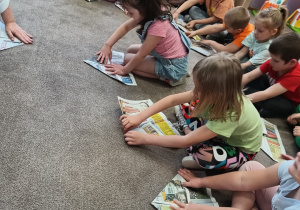 Dzieci ze starszej grupy samodzielnie składają czapkę z gazety.