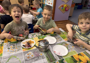 Trzech chłopców siedzi przy stoliku i tworzą swoją mieszankę herbat.