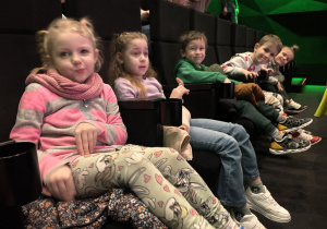 Dzieci siedzą w kinie przed seansem.