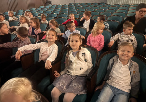 Grupa dzieci siedzi na miejscach w Teatrze Piccolo.
