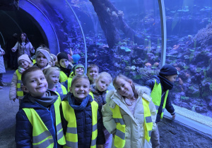 Dzieci pozują do zdjęcia w podwodnym tunelu.