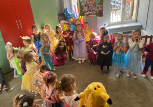 Dzieci ustawione w kole bawią się do muzyki.