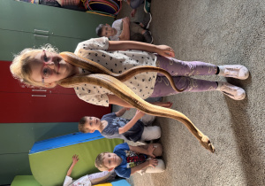 Dziewczynka z boa na szyi pozuje do zdjęcia.