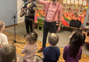 Pan Jacek zachęca dzieci do śpiewu.