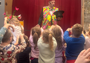 Magik trzyma czarny cylinder, z którego za moment wyczaruje królika.