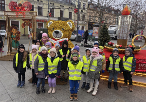 Dzieci pozują do zdjęcia na tle dekoracji świątecznej na ul. Piotrkowskiej.