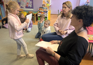 Dziewczynka przygląda się sytuacji przedstawionej na obrazku.