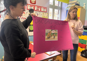 Panie psycholog i logopeda trzymają plakat wykonany z pomocą dzieci.