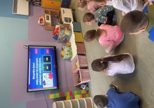 Dzieci siedzą na dywanie i rozwiązują quiz na temat praw dziecka.