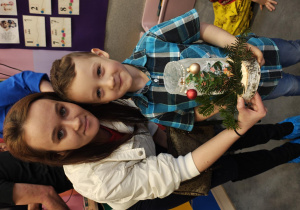 Chłopiec z mamą pozuje do zdjęcia. W rękach chłopiec trzyma lampion, który zrobił razem z mamą.