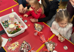 Dzieci z rodzicami wykonują kule śnieżne.