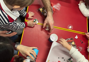 Rodzice pomagają swoim dzieciom robić kule śnieżne.