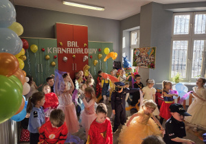 Dzieci w przebraniach bawią się na balu.