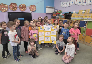 Dzieci trzymają w rękach wspólnie wykonany plakat na temat bezpiecznego korzystania z Internetu.