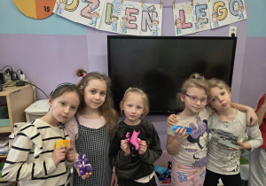 Pięć dziewczynek pozuje do zdjęcia ze zbudowanymi konstrukcjami.