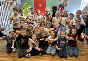 Grupa dzieci pozuje do zdjęcia z alpakami.