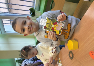 Chłopiec pokazuje wykonaną przez siebie kartkę wiosenną.