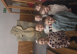 Szóstka dzieci stoi w szkolnym pomieszczeniu.