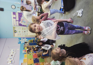 Dziewczynka w temblaku pozuje do zdjęcia.