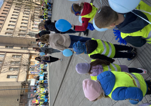 Dzieci z łódzkich przedszkoli stoją w kręgu na Pasażu Schillera.