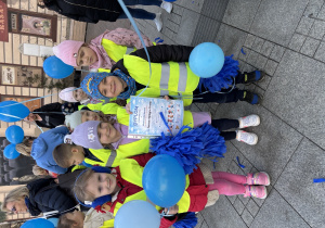 Dzieci pozują do zdjęcia z dyplomem.