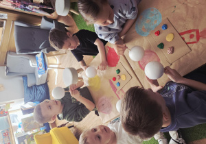 Dzieci malują farbami steropianowe kule, z których powstaną planety.