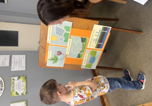 Chłopiec przygląda się planszom, na których przedstawione są źródła energii.